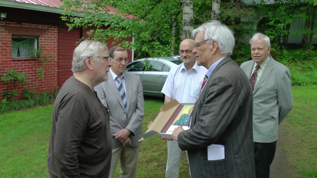 Yhdistyksen varapuheenjohtaja Lasse Nirhamo luovuttaa päivänsankari Tenho Tikkaselle teoksen Ylipäällikön päiväkäskyt. Kuvassa myös vasemmalta Antti Haapalainen, Pentti Kärkkäinen ja Mauri Mönkkönen. - Kuva: Antero Huttunen. 